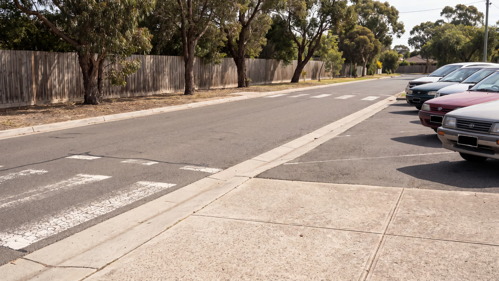 Elevated view of a generic inland suburban school frontage with vehicles, marked bays and an abstract review tablet