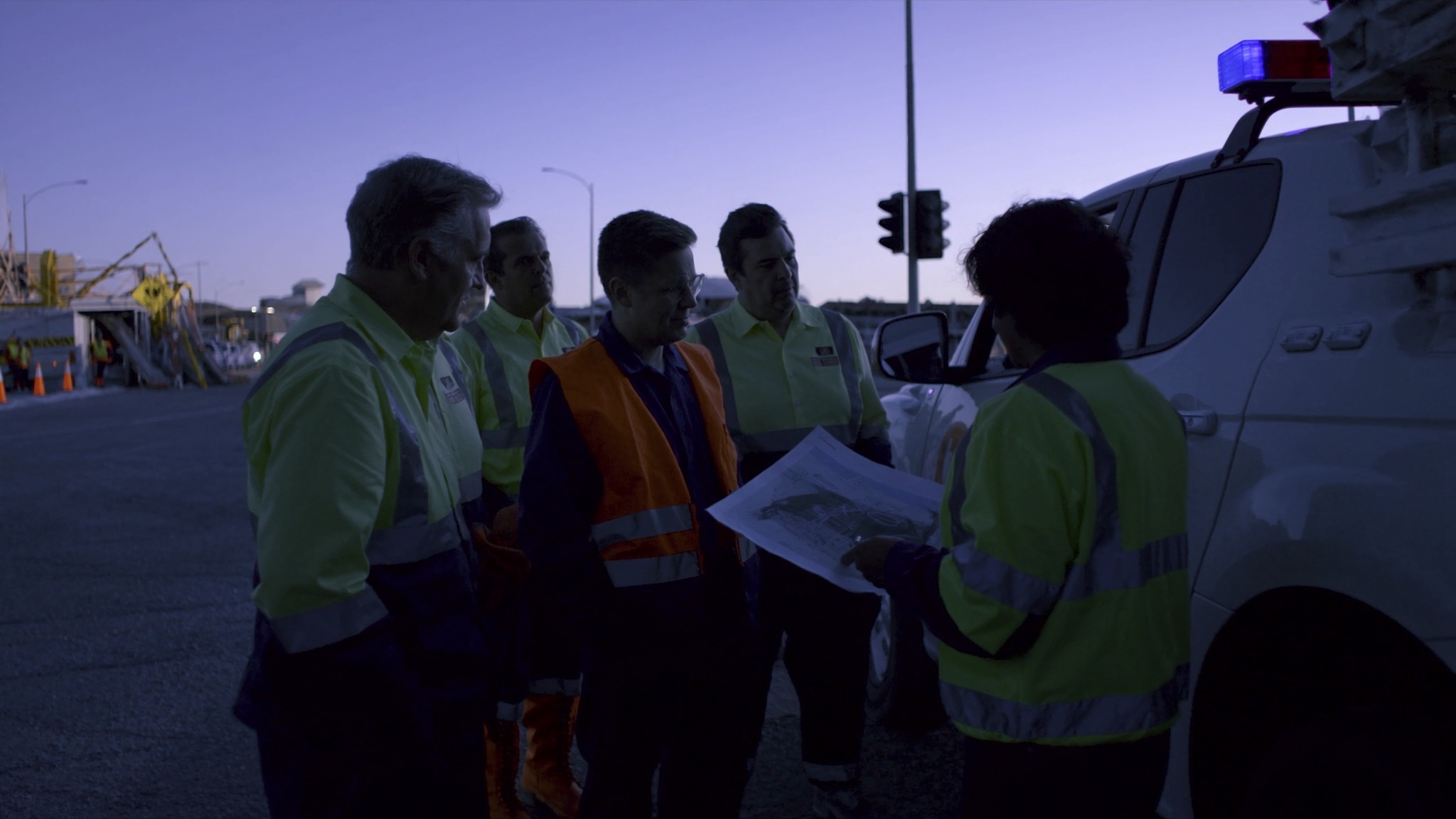 Australian traffic-control crew reviewing a site plan during a shift handover