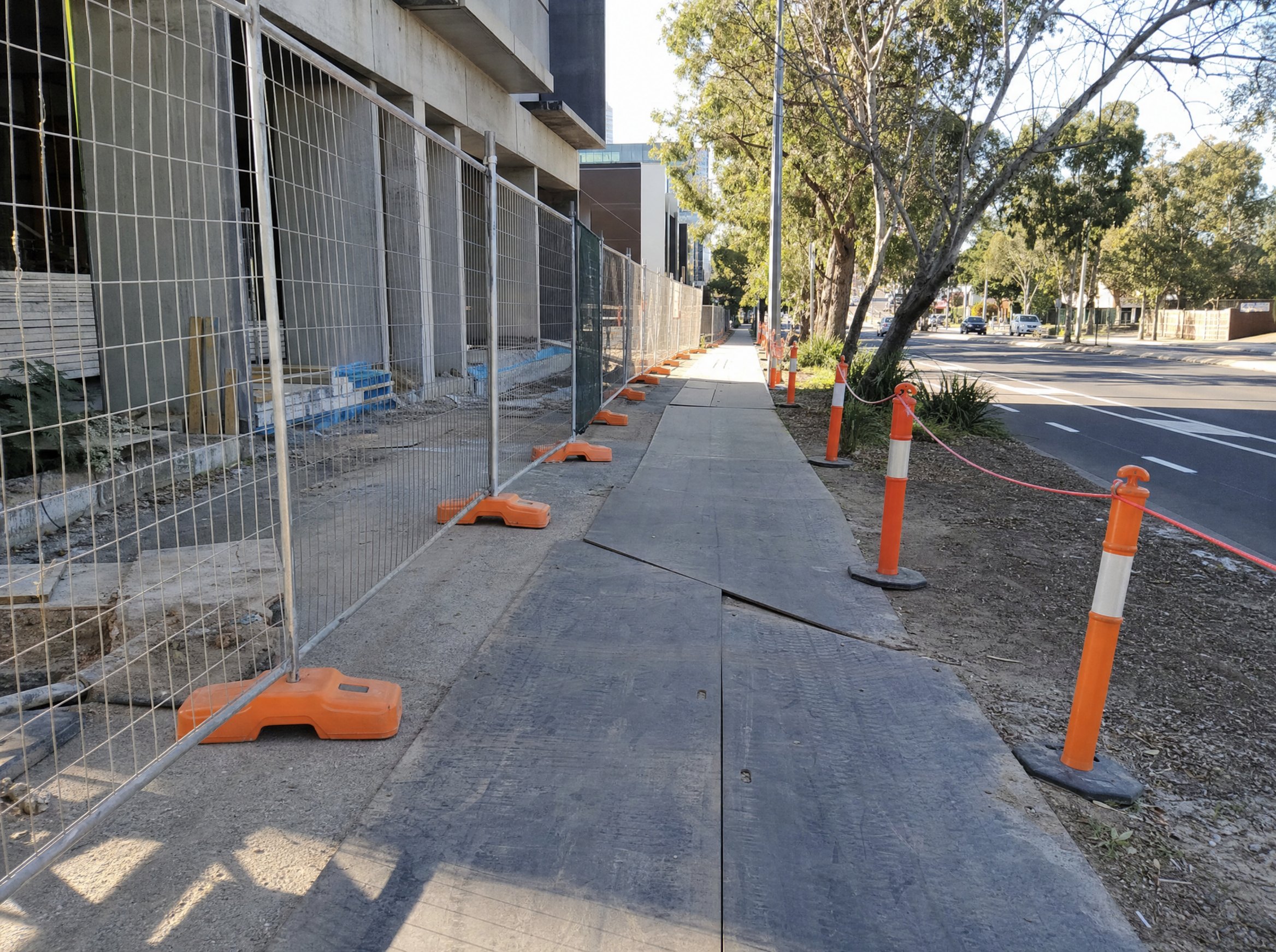 Footpath works area with temporary fencing and safe pedestrian context